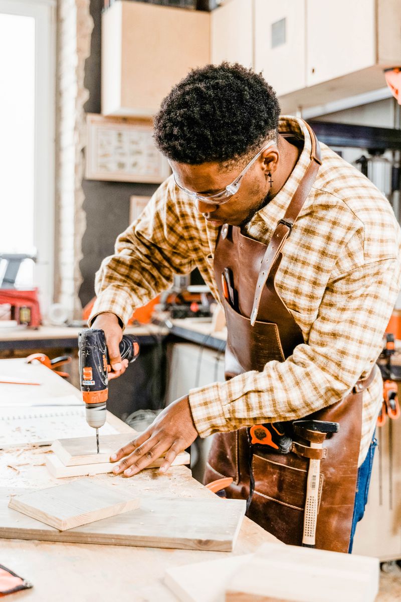Azubi arbeitet in der Werkstatt mit Bohrmaschine