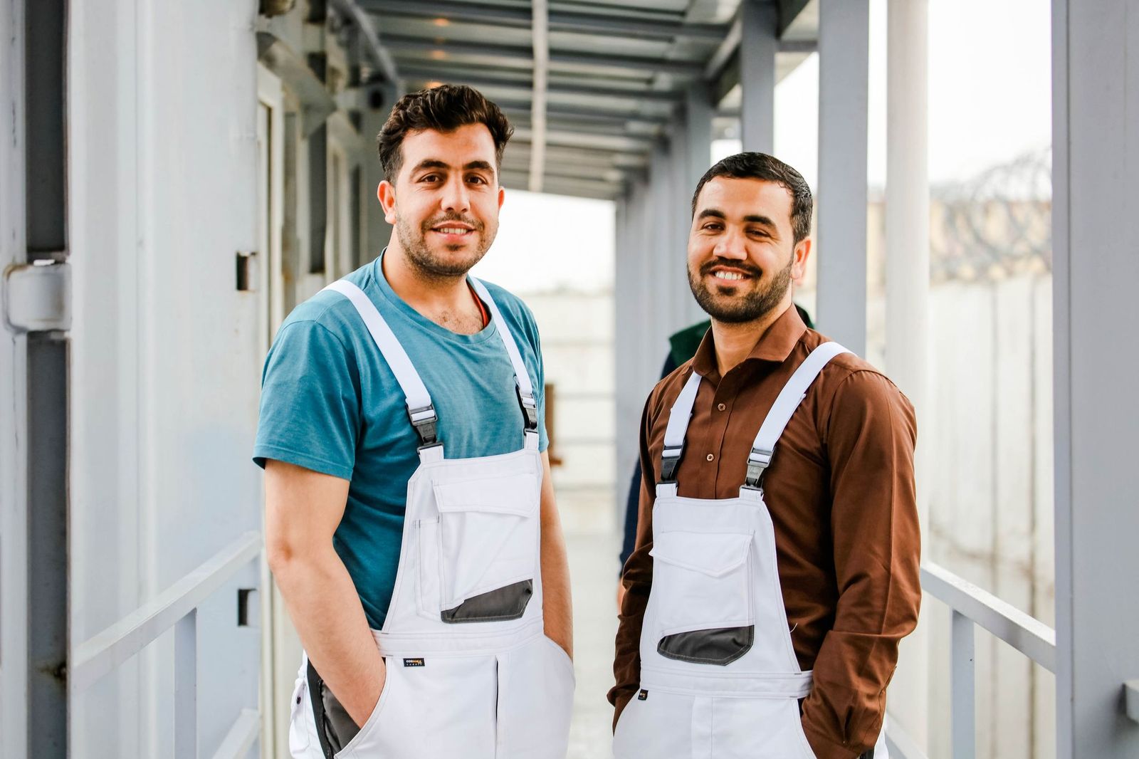 Zwei junge Handwerker stehen gemeinsam auf einer Baustelle